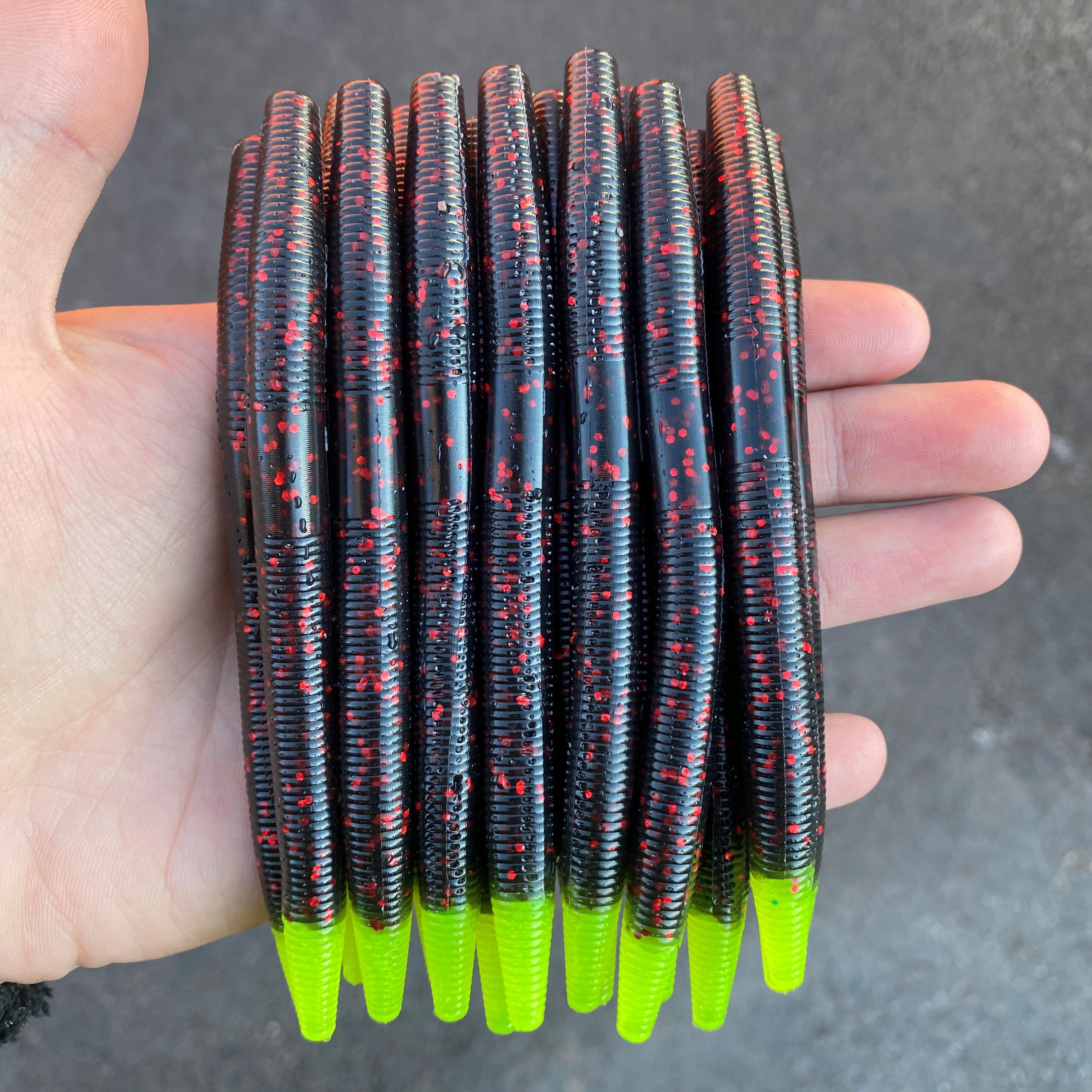 black with red flake and chartreuse tails pile in hand outdoors