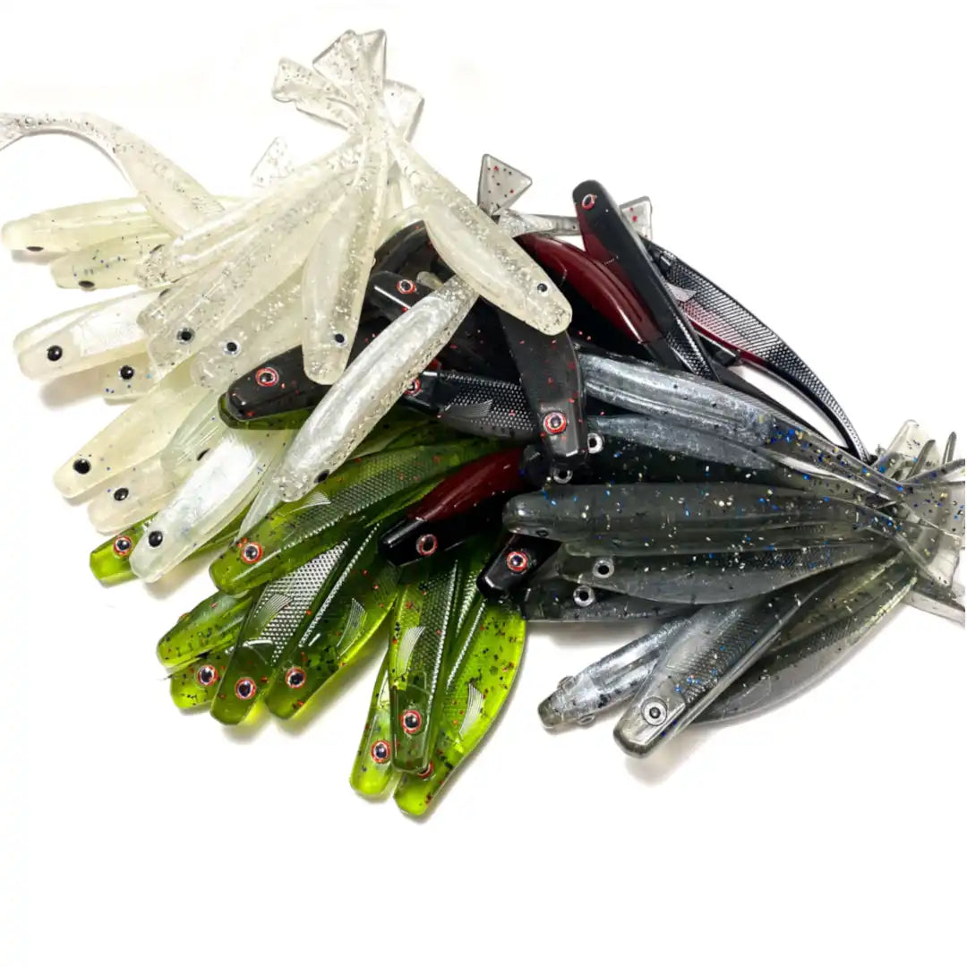 Collection of soft plastic fishing lures in white, green, and black colors.