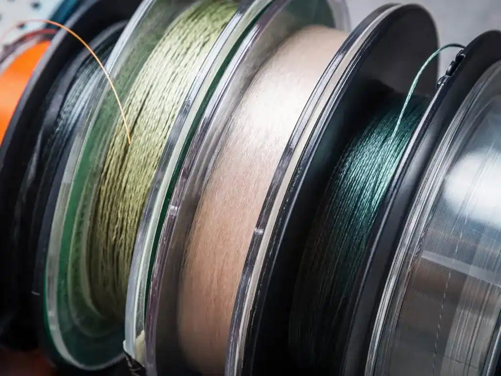 Fishing line spools in various colors lined up together.