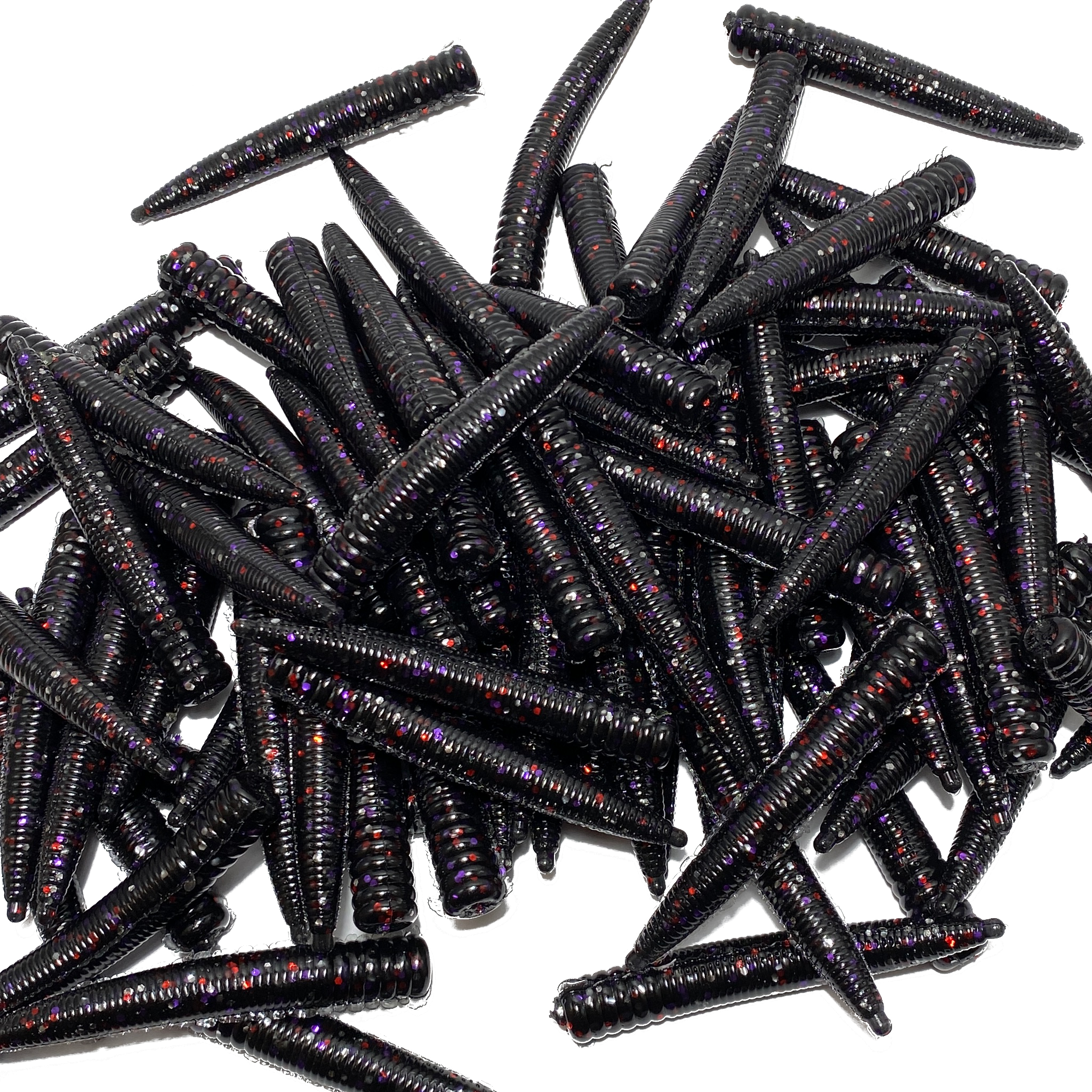 Pile of black fishing lures with red and purple glitter on a white background