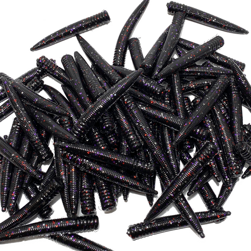 Pile of black fishing lures with red and purple glitter on a white background